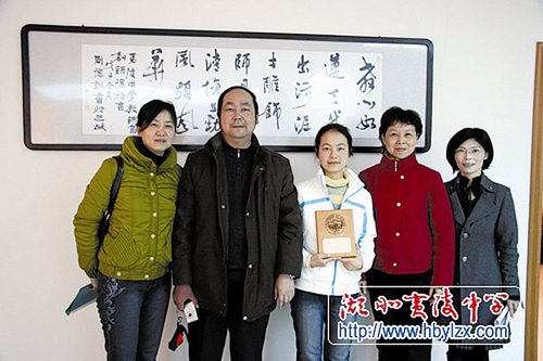 图为:熊文苑与父母及老师合影(本版图片来源:夷陵中学网)
